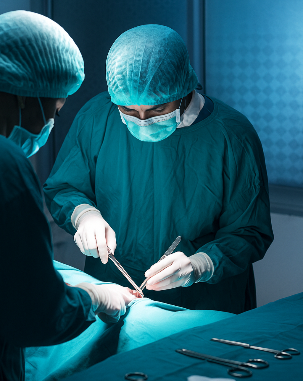 Two surgeons in blue scrubs performing surgery, showcasing medical oncologist teamwork in action.